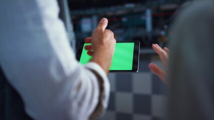 Engineer hands holding tablet computer with chroma key screen at farm facility.