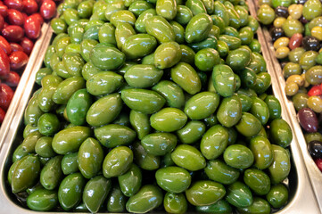 Green fresh olives close up on market, food background