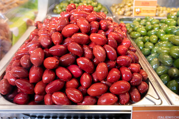 Red olives close up on market, food background