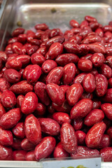 Red olives close up on market, food background