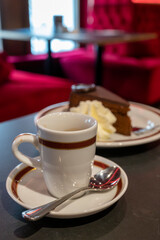 Small cup of black espresso coffee served in traditional cafe in Vienna with red interieur, Austria