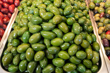 Green fresh olives close up on market, food background