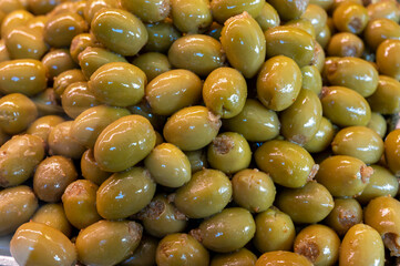 Green fresh olives close up on market, food background