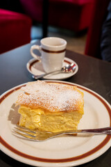 Austrian sweet dessert, filled with white cheese strudel served warm in traditional cafe in Vienna, Austria with cup of black coffee