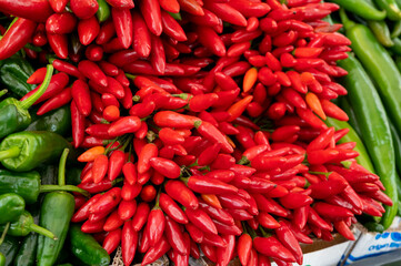 Bunches of red hot chili peppers for sale on market