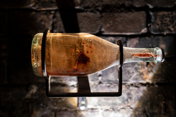 Sparkling wine production by traditional methods in underground cellars in Vienna, Austria. Sediment in bottle.