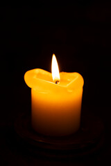 One burning candle in dark underground shelter