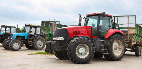 Agricultural machinery, tractors and equipment outdoors, near the garage, ready to work in the field.