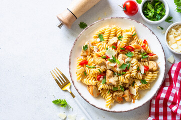 Italian pasta with tomato sauce, basil and parmesan cheese on white table.