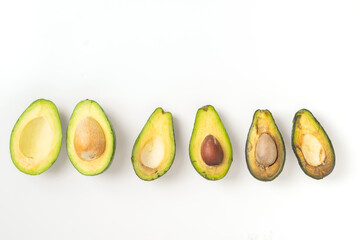 Ripe and spoiled rotten fruit vegetables avocado in a cut, white background, copy space