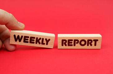 On a red background, wooden blocks, one of them in hand. The blocks are written - WEEKLY REPORT