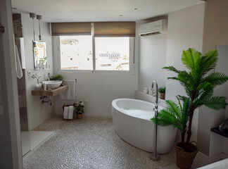 Interior of cozy nice bathroom with hot bubbling bathtub, window and mirror. Empty room.