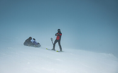 Skier and snowboarders are preparing to descend the mountain.