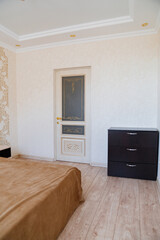 chest of drawers and a classic white door in the bedroom. 