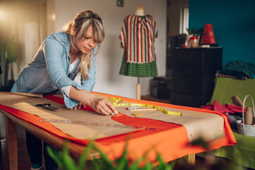 Woman tailor working from home and tailoring beautiful clothes