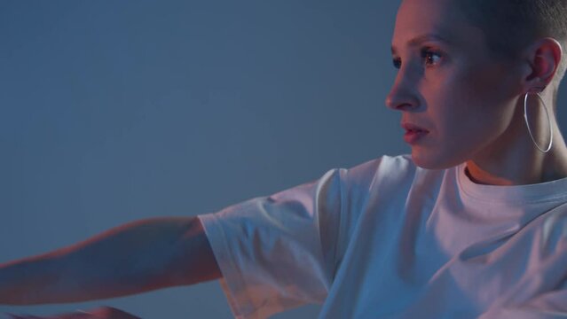Dancing young girl with short haircut cool moving with hands at camera in studio. Nightlife. Contemporary dance. ProRes