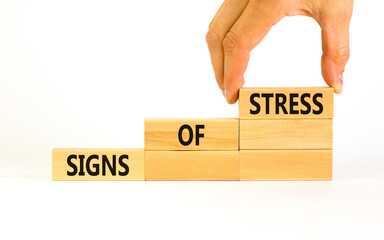 Signs of stress symbol. Concept words Signs of stress on wooden blocks. Beautiful white table white background. Doctor hand. Psychological business and signs of stress concept. Copy space.