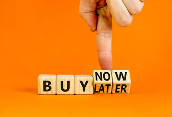 Buy later or now symbol. Businessman turns wooden cubes and changes concept words Buy later to Buy now. Beautiful orange table orange background. Business buy later or now concept. Copy space.