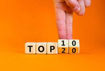 From Top 20 to 10 symbol. Businessman turns wooden cubes and changes concept words Top 20 to Top...