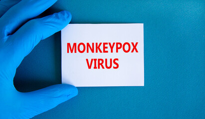 Monkeypox virus symbol. Concept words Monkeypox virus on white card. Doctor hand in blue glove with white card. Medical and Monkeypox virus concept. Copy space.