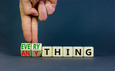 Anything or everything symbol. Businessman turns cubes and changes the concept word Anything to Everything. Beautiful grey background. Business motivational anything or everything concept. Copy space.