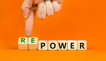 Power or repower symbol. Businessman turns wooden cubes and changes concept words Power to Repower. Beautiful orange table orange background. Business ecological power or repower concept. Copy space.