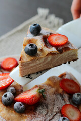 A piece of real Italian dessert Parma pudding with fresh strawberry and blueberry. It’s delicious  and tasty breakfast will literally melts in your mouth