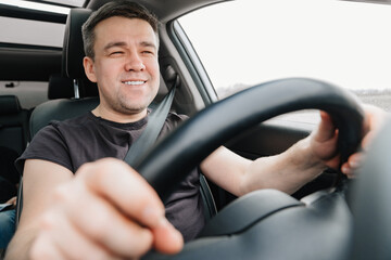 a happy man drives a car on the highway