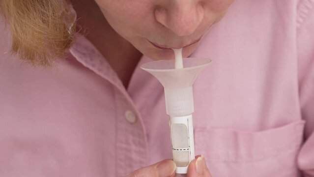 a woman collects saliva in a container for a dna test. 