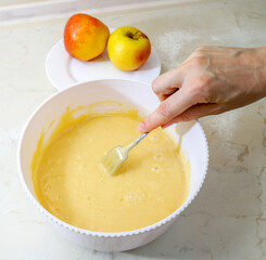 Stirring flour, eggs and sugar making dough for an apple pie