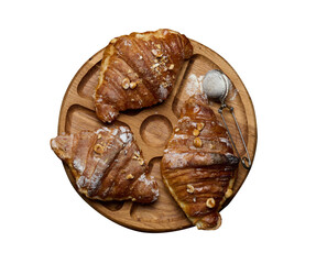 Baked croissant on a wooden board and sprinkled with powdered sugar