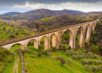 Fototapeta na wymiar Scenic drone view of green spring hilly landscape with Guadalupe viaduct built in early 20th century, planned as railway bridge, Spain..