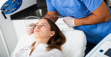 Female client getting carbon dioxide injections for face skin rejuvenation in clinic of aesthetic...