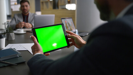 Coworker man scrolling tablet green screen browse web on business meeting table.