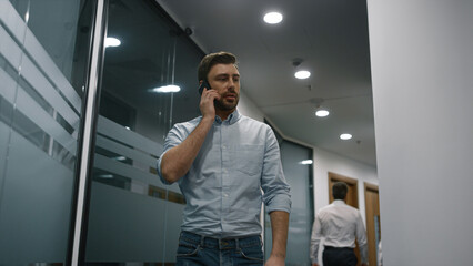 Serious executive phone talking in office. Businessman discuss plan in company.