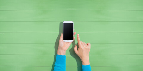 Person using a white smartphone - overhead view - obrazy, fototapety, plakaty