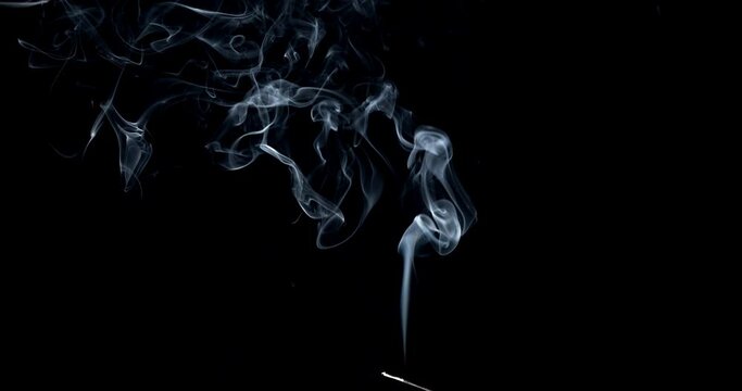 Real smoke on a black background. Thin Flexible Trickle of Real Smoke. Colorful real smoke rises up. Ideal for background or over-layer with blending mode add, screen, lighten.