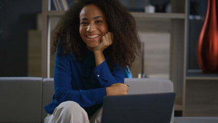 Relaxed corporate woman looking camera smiling posing in home office workplace.