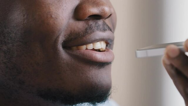 Close up male face african american man worker record voice audio message use smartphone digital translator chat in social app talk information say text on speakerphone set reminder virtual assistance