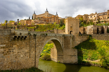 Fototapeta na wymiar Picturesque landscape with a view of the Alcantara Bridge, spanning the Tagus River, and the ancient Alcazar de Toledo ..Castle, located in the upper part of the city of Toledo, Spain