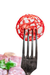 Slice of chorizo sausage on a fork isolated on white