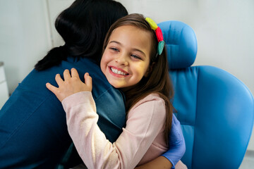 Cute little girl giving affectionate hug to her dentist 