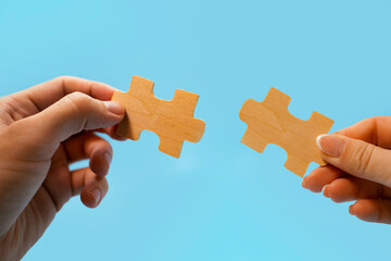 Man and woman holdig two puzzle peaces in their hands