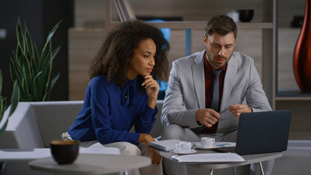 Mixed race business couple working laptop computer at remote workplace office.