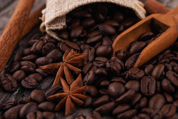 chocolate, cinnamon sticks  and coffee beans on wooden background