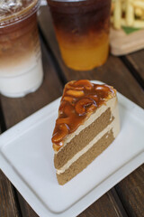 Toffee cake with with caramelly cashew crust on top served on a white plate. Homemade cake.