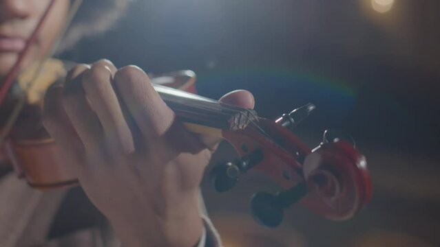 Close up view of young talented African American violinist playing classical music with fiddle