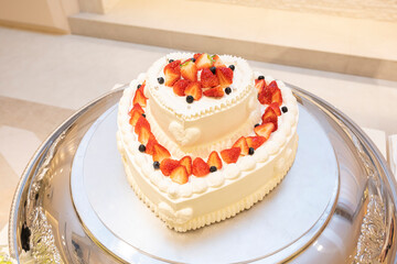 Obraz na płótnie Canvas Heart-shaped cake with lots of strawberries