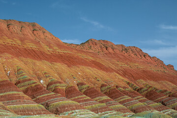 Horizontal picture of the red, yellow, orange layers of the Chinese rainbow mountains of Zhangye Danxia National Geological park, Gansu, China