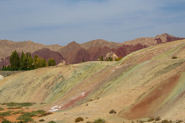 Dark red, yellow and green geological layers with blue sky and copy space for text, Zhangye Danxia Geological park, Gansu, China